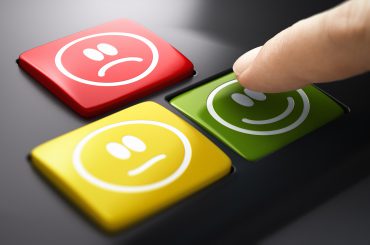 Dedo sobre teclado com emojis de satisfação