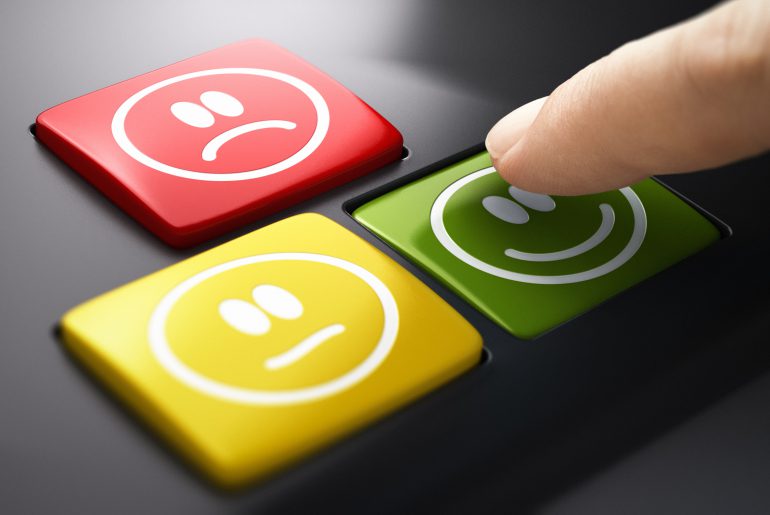 Conheça as principais funcionalidades de um software de NPS Dedo sobre teclado com emojis de satisfação