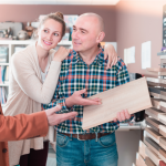 Vendedor apresenta produto para casal heterossexual